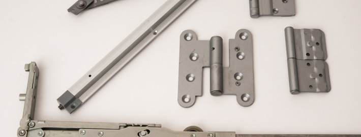 Hinges and sliding door gear for windows and doors + surface treatment